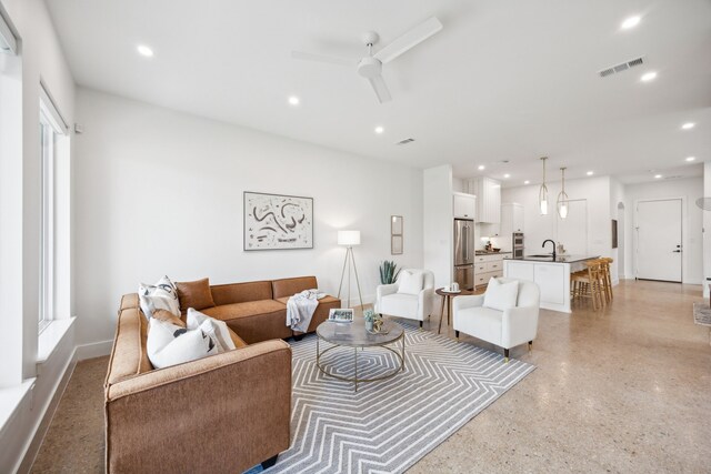 living room featuring ceiling fan and sink