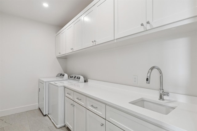 laundry area with light tile patterned flooring, cabinets, independent washer and dryer, and sink