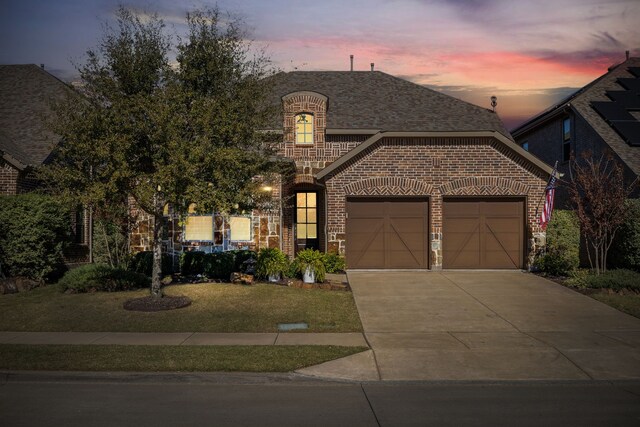 view of front of property with a garage and a yard