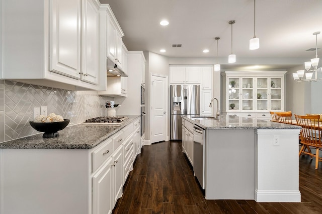 kitchen with pendant lighting, sink, an island with sink, and white cabinets