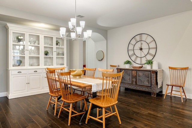 dining area with dark hardwood / wood-style flooring and a notable chandelier