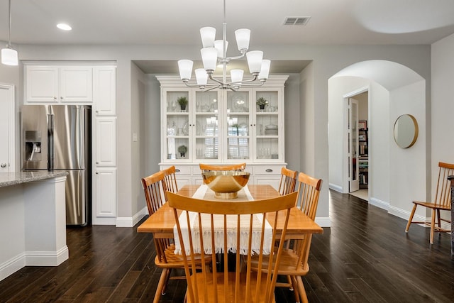 dining area with dark hardwood / wood-style flooring and a chandelier