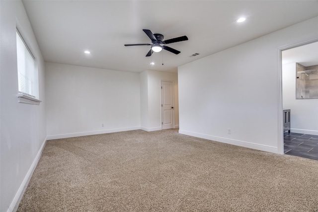 spare room with dark colored carpet and ceiling fan