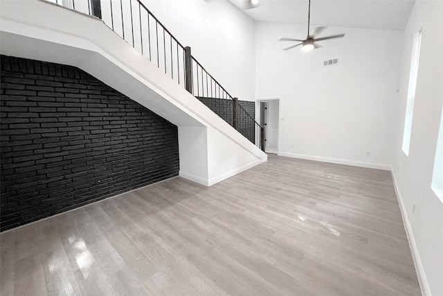 interior space featuring a high ceiling, ceiling fan, and light hardwood / wood-style floors