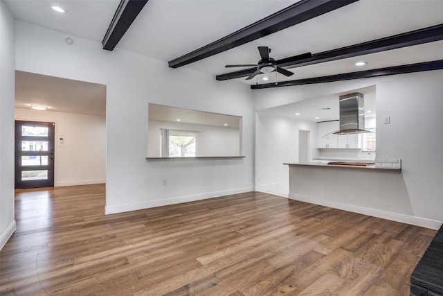 unfurnished living room with beam ceiling, hardwood / wood-style flooring, and a wealth of natural light