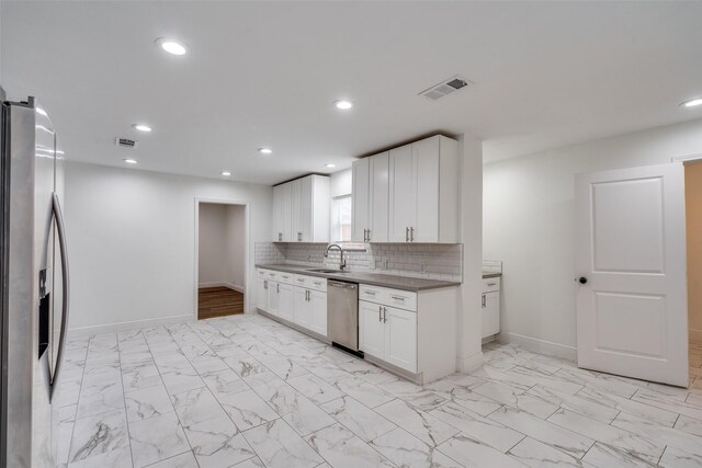 kitchen featuring white cabinets, decorative backsplash, stainless steel appliances, and sink