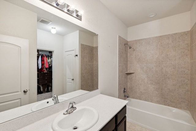 bathroom featuring vanity, tiled shower / bath combo, and tile patterned flooring