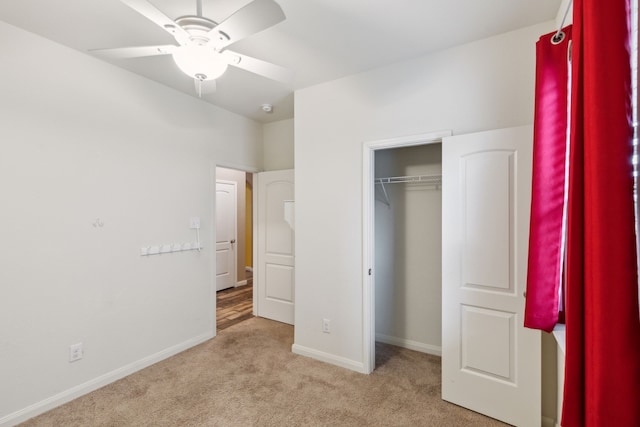 unfurnished bedroom featuring ceiling fan, light colored carpet, and a closet