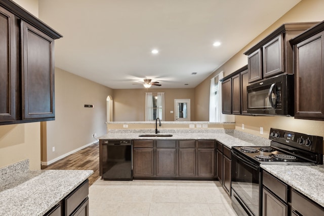 kitchen featuring kitchen peninsula, sink, dark brown cabinets, and black appliances