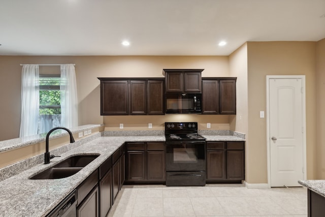 kitchen featuring sink, light tile patterned floors, dark brown cabinets, black appliances, and light stone countertops