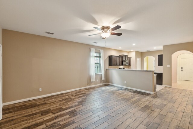 unfurnished living room featuring dark hardwood / wood-style floors and ceiling fan