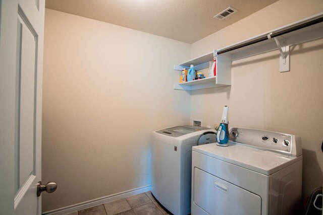 washroom featuring separate washer and dryer and light tile patterned floors