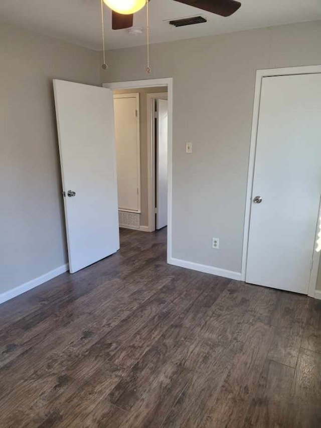 unfurnished room featuring ceiling fan and dark hardwood / wood-style flooring