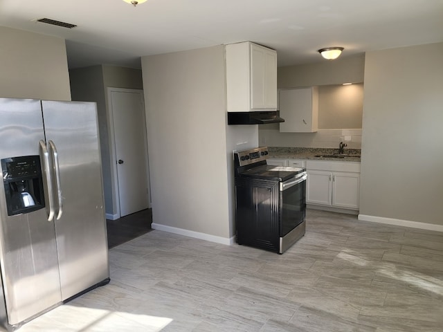 kitchen featuring appliances with stainless steel finishes, light stone countertops, sink, and white cabinets