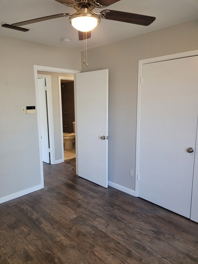 unfurnished bedroom featuring ceiling fan and dark hardwood / wood-style flooring