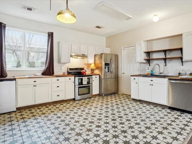 kitchen featuring pendant lighting, sink, white cabinetry, a textured ceiling, and stainless steel appliances