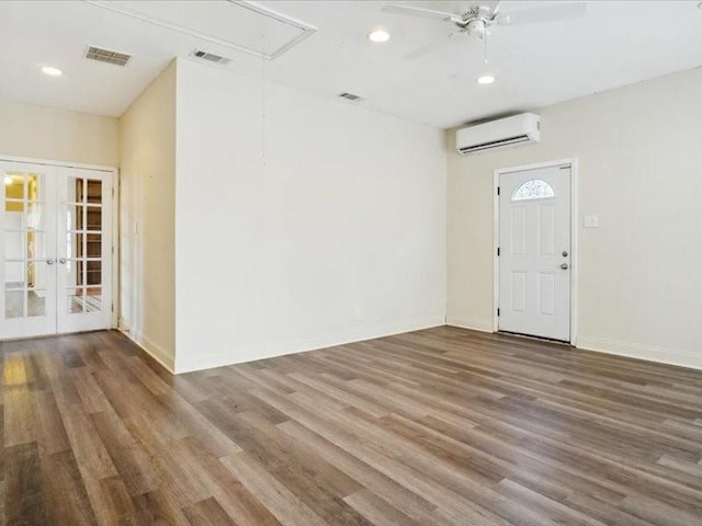 entryway with ceiling fan, hardwood / wood-style floors, french doors, and a wall mounted air conditioner