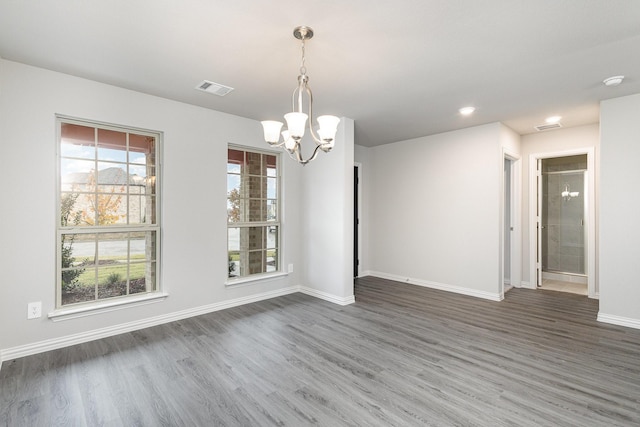 unfurnished dining area with dark hardwood / wood-style flooring and a chandelier