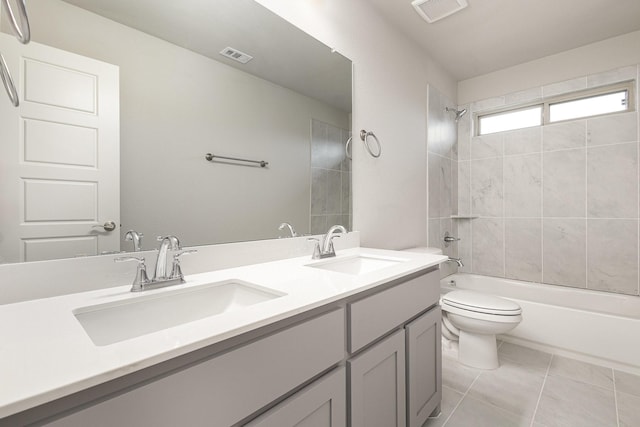 full bathroom featuring vanity, tiled shower / bath combo, toilet, and tile patterned flooring