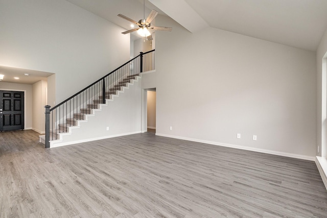 unfurnished living room with hardwood / wood-style flooring, high vaulted ceiling, and ceiling fan