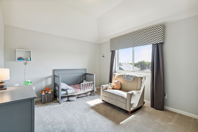 bedroom with a nursery area, light carpet, and vaulted ceiling