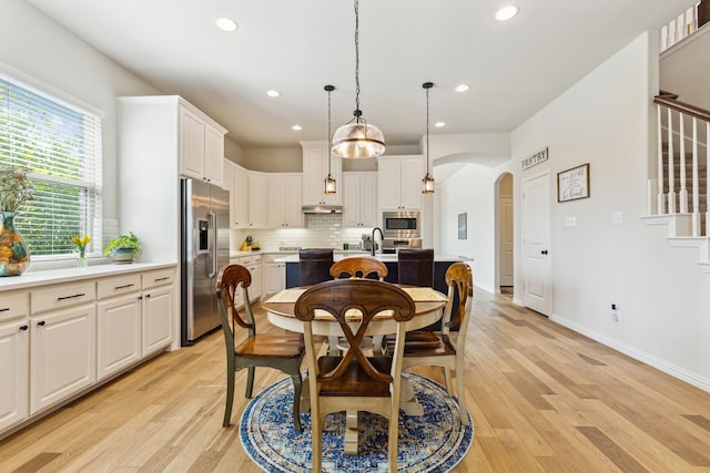 dining space with sink and light hardwood / wood-style floors