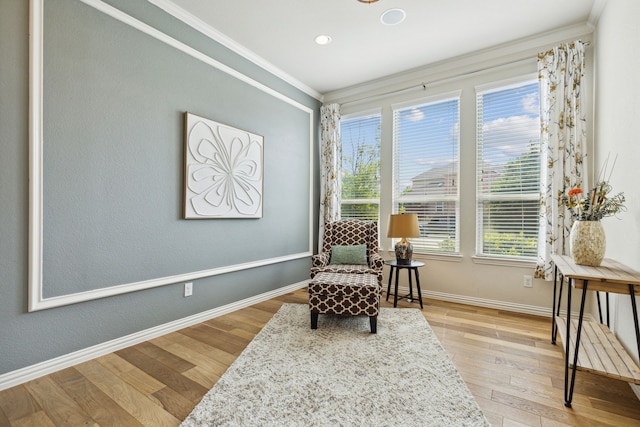 sitting room with wood-type flooring and ornamental molding