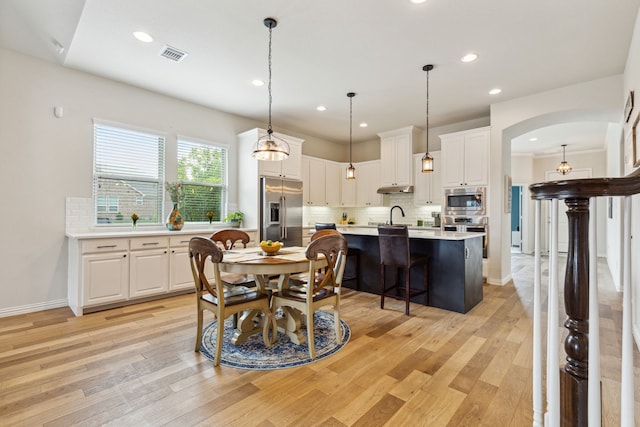 dining space with sink and light hardwood / wood-style flooring