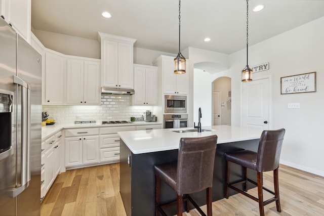 kitchen featuring sink, white cabinets, an island with sink, and appliances with stainless steel finishes