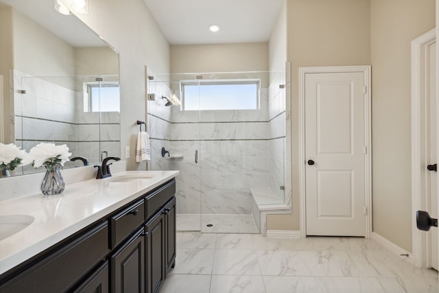 bathroom featuring a shower with door and vanity