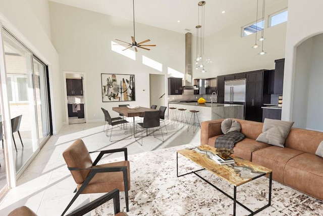 living room featuring a ceiling fan, arched walkways, marble finish floor, and recessed lighting