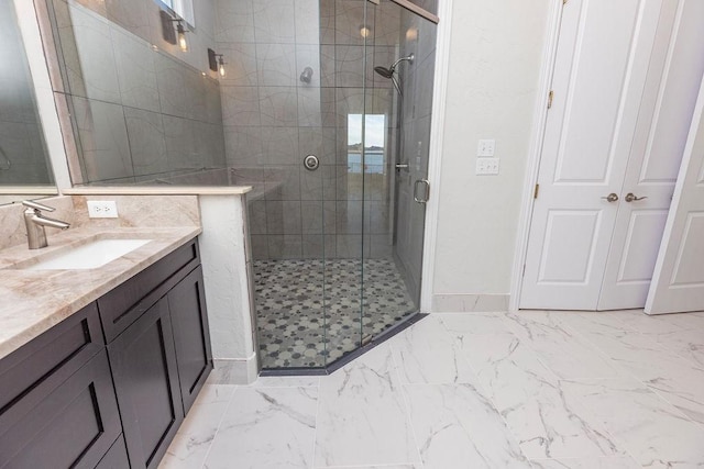 full bathroom with marble finish floor, vanity, baseboards, and a stall shower