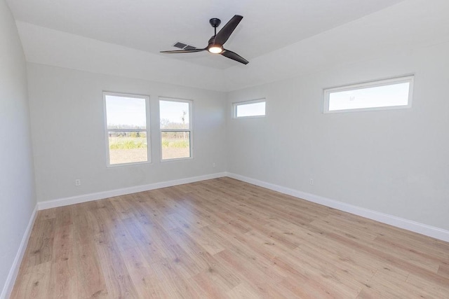 empty room featuring light wood-style floors, visible vents, ceiling fan, and baseboards