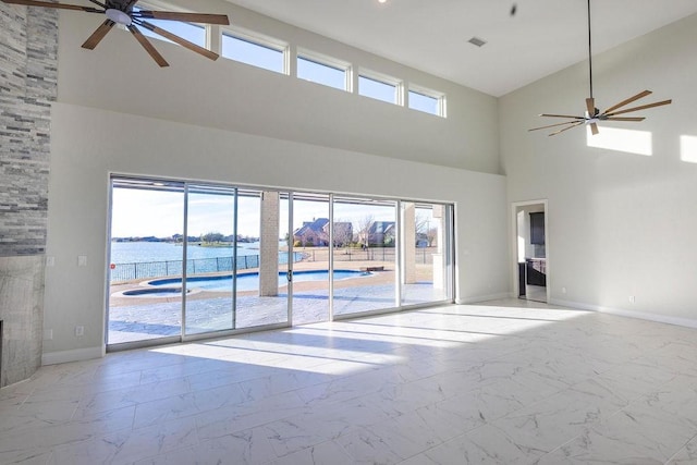 spare room featuring marble finish floor, ceiling fan, and baseboards