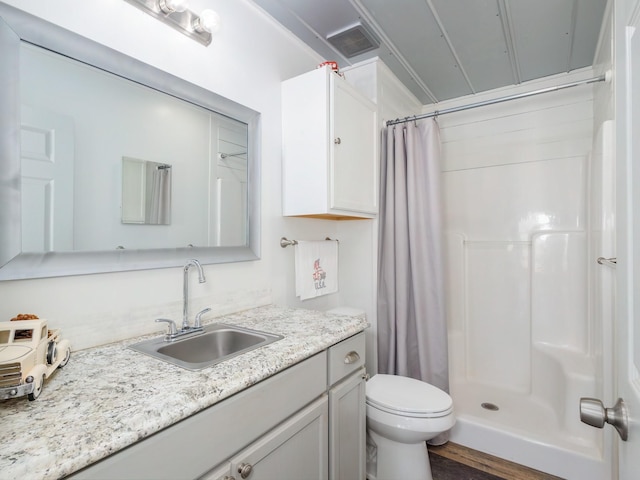 bathroom featuring vanity, toilet, a shower with shower curtain, and hardwood / wood-style floors