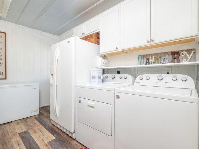 laundry area featuring dark hardwood / wood-style floors, washer and clothes dryer, and cabinets