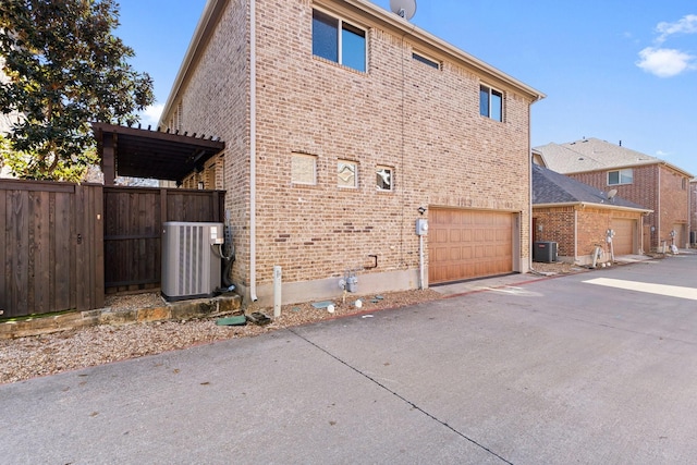 view of home's exterior featuring central air condition unit and a garage