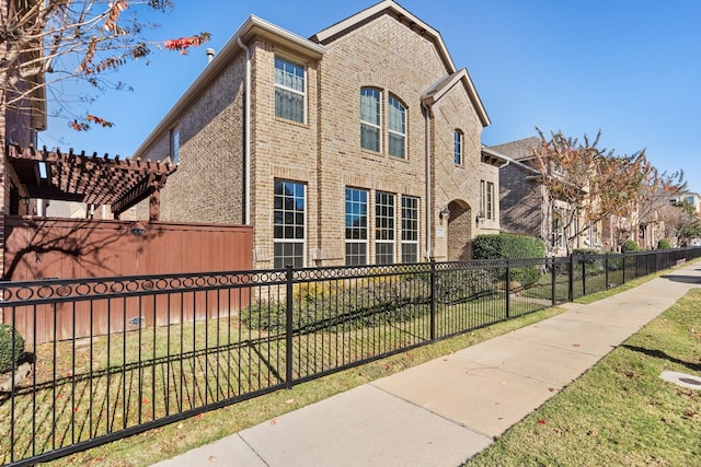 view of side of property with a yard and a pergola