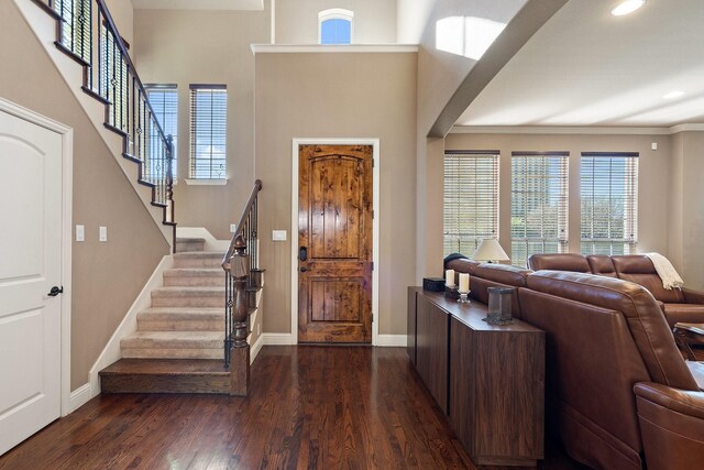 entryway with ornamental molding and dark wood-type flooring