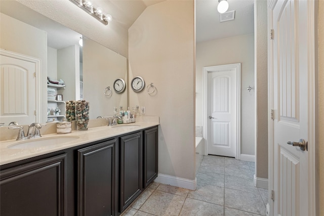 bathroom with vanity, a bath, and tile patterned flooring