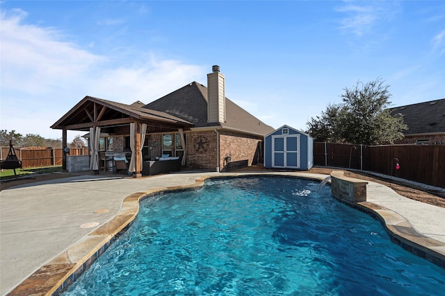 view of pool featuring a patio area, pool water feature, and a storage unit