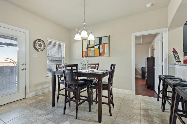 tiled dining room with an inviting chandelier