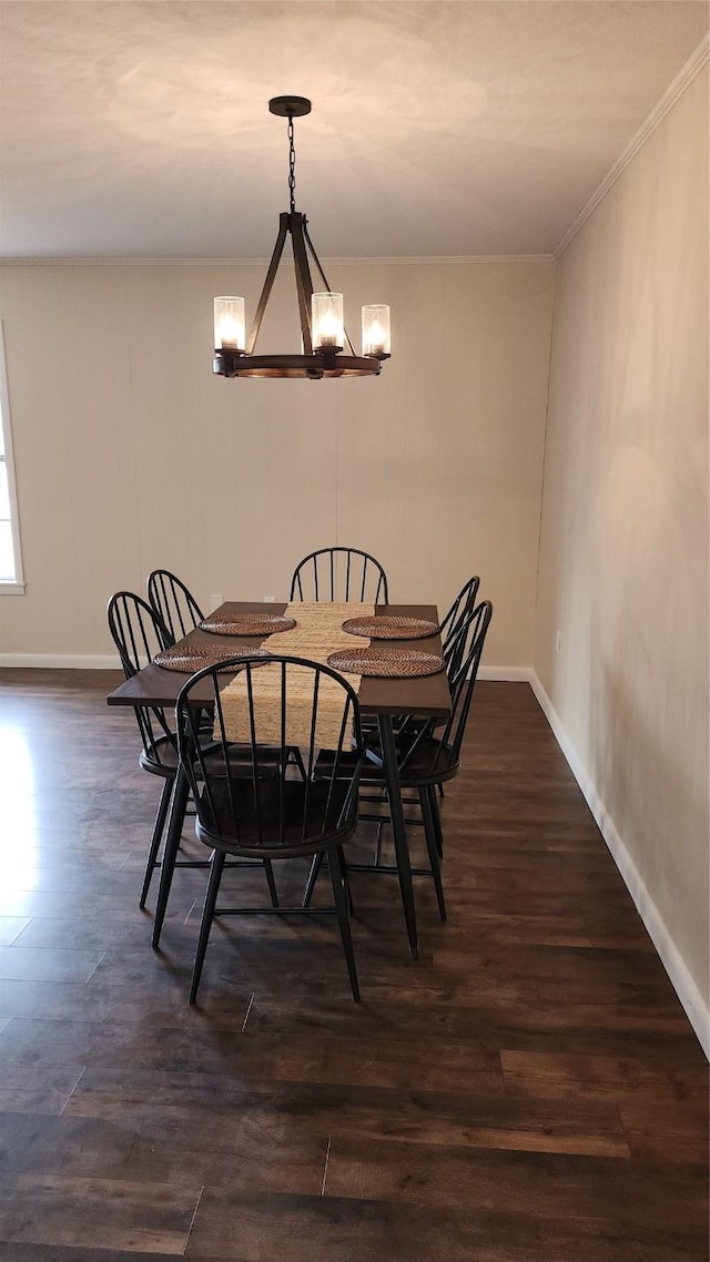 dining space featuring dark hardwood / wood-style flooring, a notable chandelier, and ornamental molding