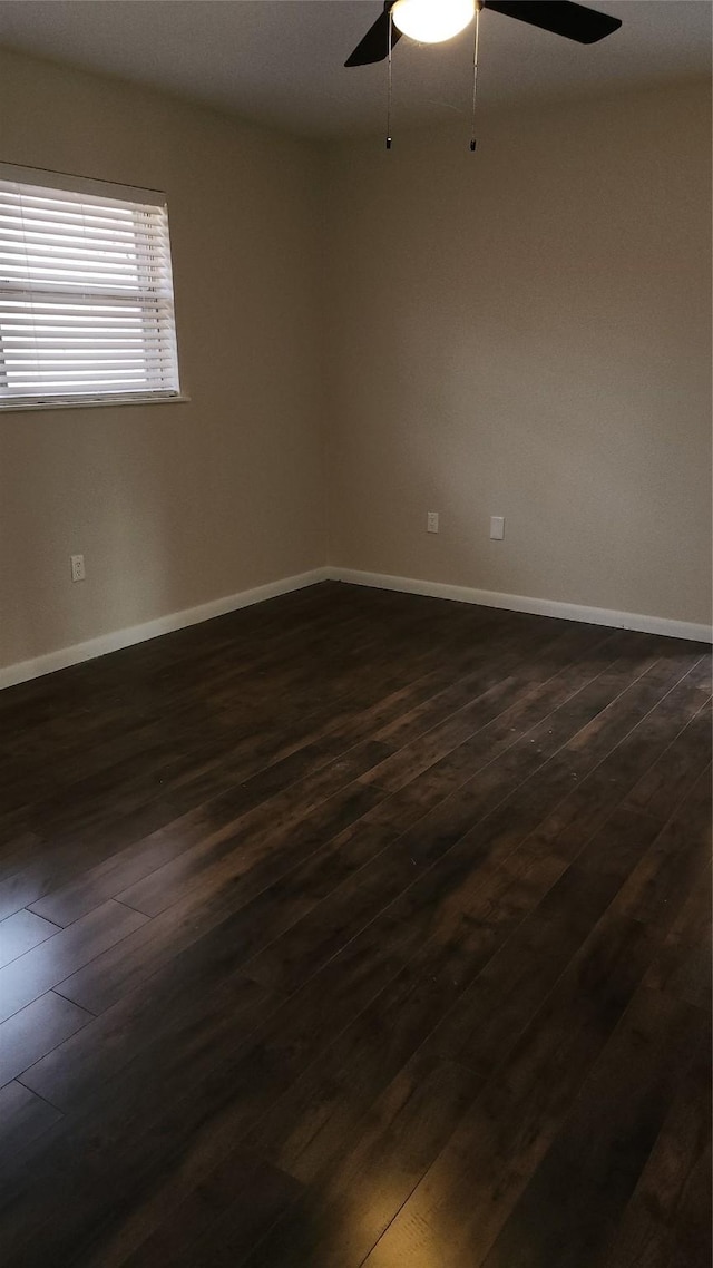 empty room with dark wood-type flooring and ceiling fan