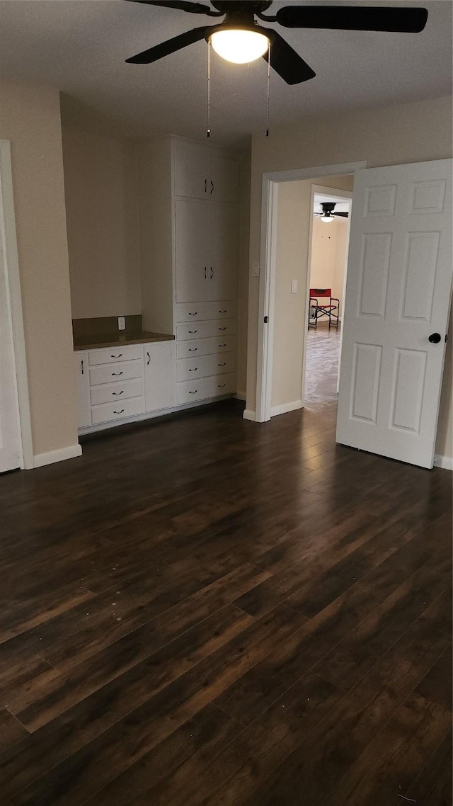 spare room featuring dark wood-type flooring and ceiling fan