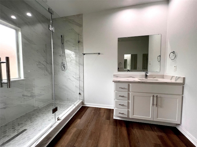 bathroom with hardwood / wood-style flooring, vanity, and walk in shower