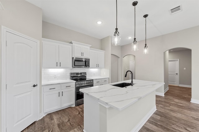 kitchen featuring white cabinets, a center island with sink, sink, light stone countertops, and appliances with stainless steel finishes