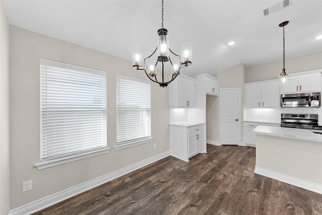 kitchen featuring decorative backsplash, white cabinetry, pendant lighting, and stainless steel appliances