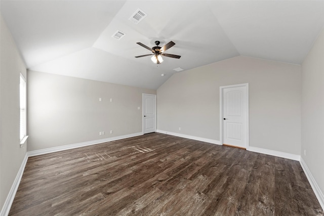 spare room featuring dark hardwood / wood-style floors, ceiling fan, and vaulted ceiling