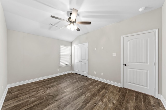 unfurnished bedroom with dark hardwood / wood-style flooring, vaulted ceiling, and ceiling fan